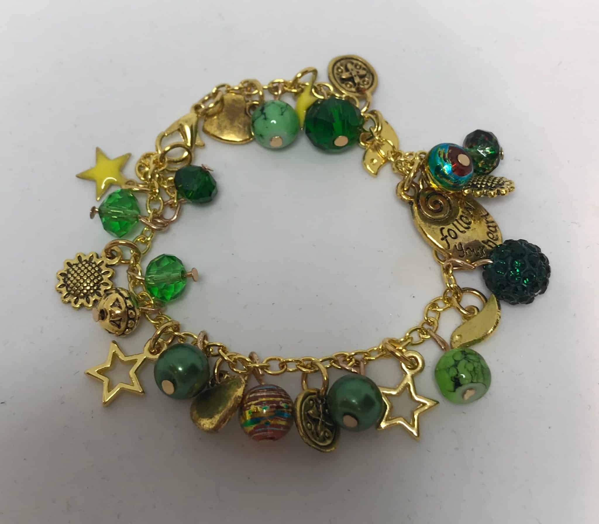Gold charm bracelet with green beads .